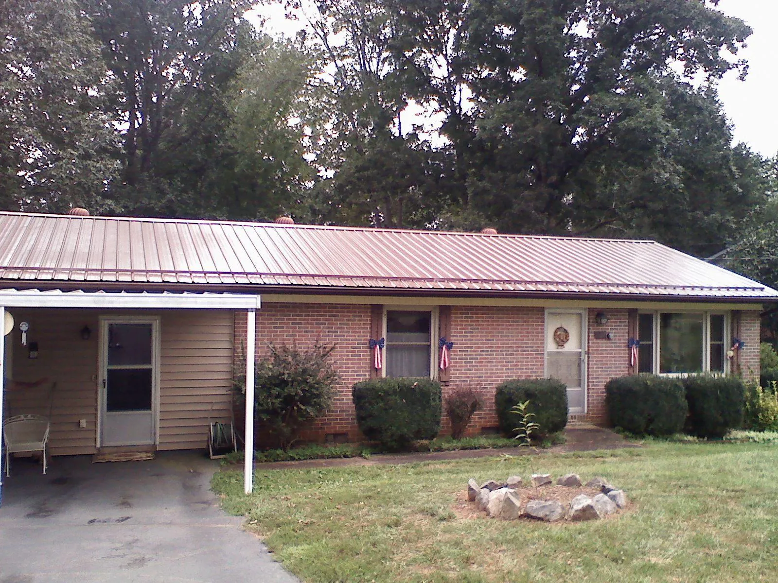 Bronze metal roof and carport on a brick ranch home — Roof Repair work by our crew in Porter